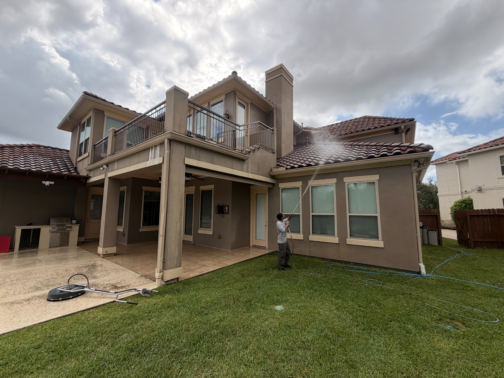 G&G team member soft washing a two-story Houston home